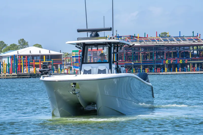 Slide: The Image of 2024 Invincible 33 Catamaran cruising near colorful waterfront buildings. - 36