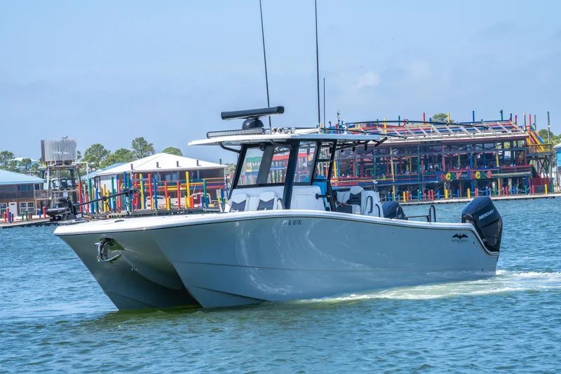 Slide: The Image of 2024 Invincible 33 Catamaran cruising on water near colorful waterfront buildings. - 37