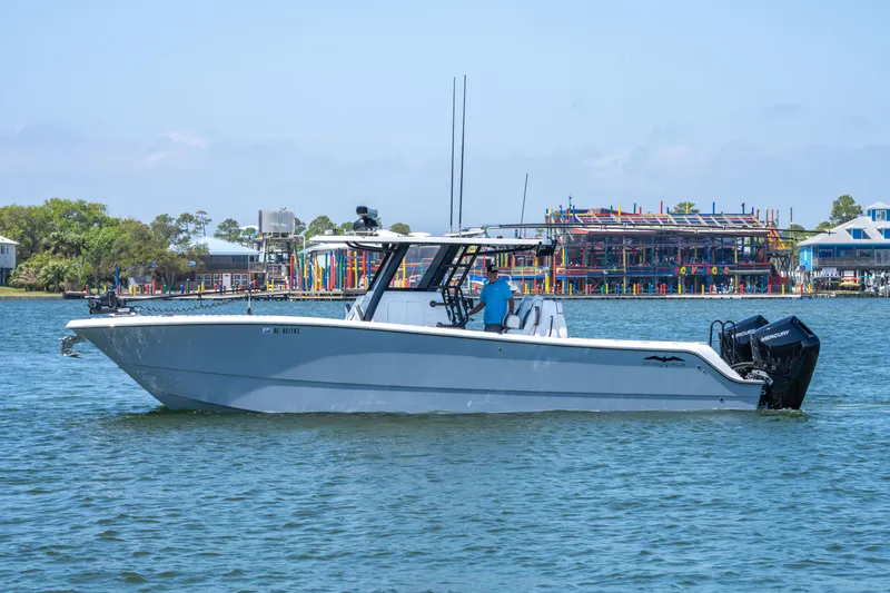 Slide: The Image of 2024 Invincible 33 Catamaran on water, side view, with colorful buildings in background. - 38