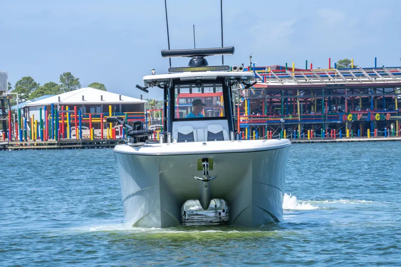 Slide: The Image of 2024 Invincible 33 Catamaran cruising on water near colorful waterfront buildings. - 39