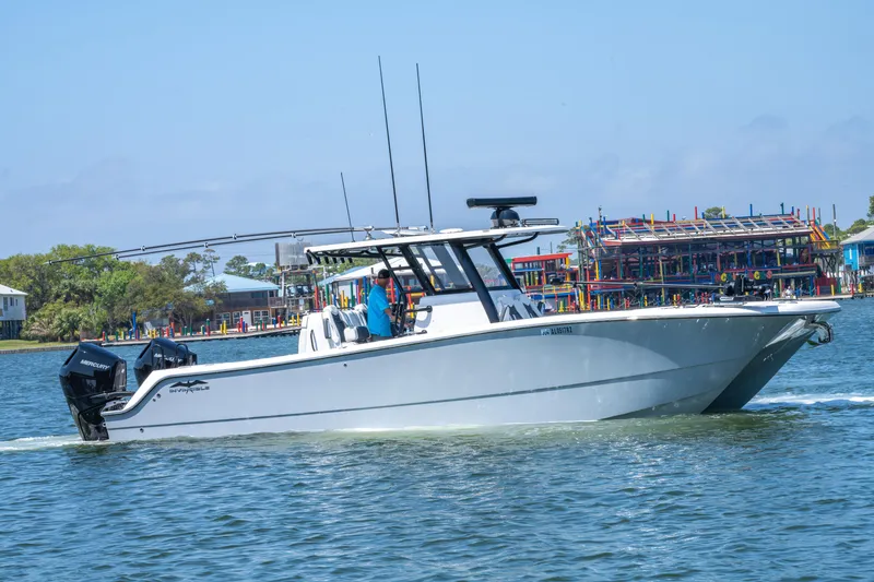 Slide: The Image of 2024 Invincible 33 Catamaran cruising on water near colorful waterfront buildings. - 40