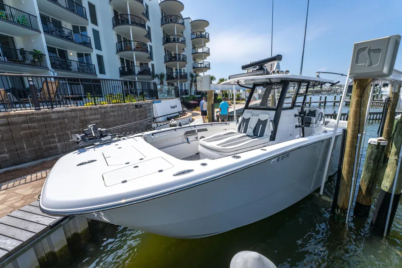 Slide: The Image of 2024 Invincible 33 Catamaran docked near waterfront apartments on a sunny day. - 42