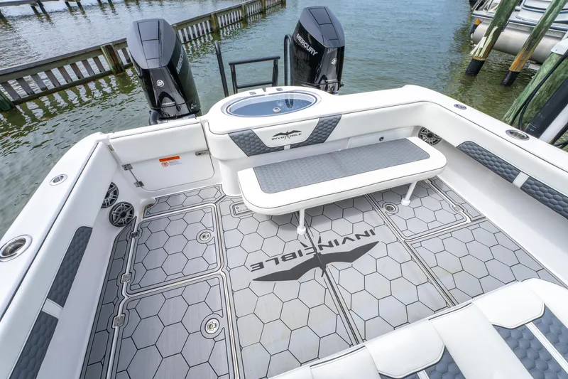 Slide: The Image of 2024 Invincible 33 Catamaran deck with seating and twin engines, docked by the water. - 5