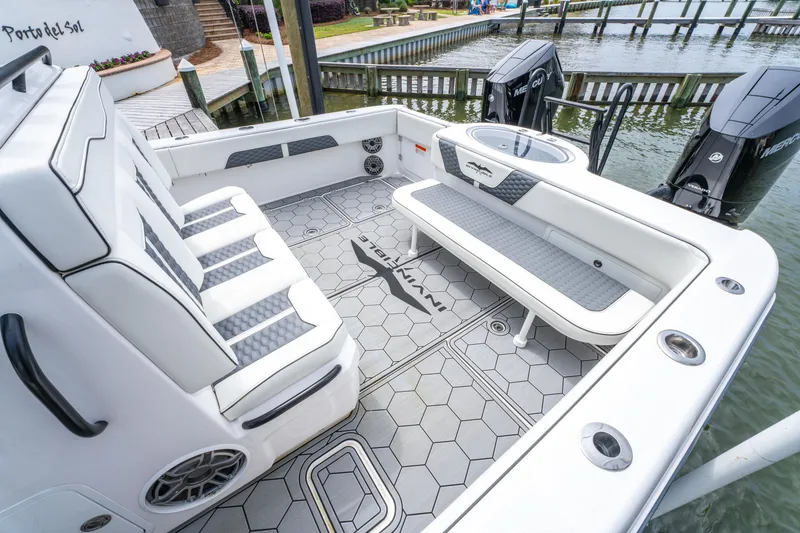 Slide: The Image of 2024 Invincible 33 Catamaran interior with seating and modern design at a dock. - 6