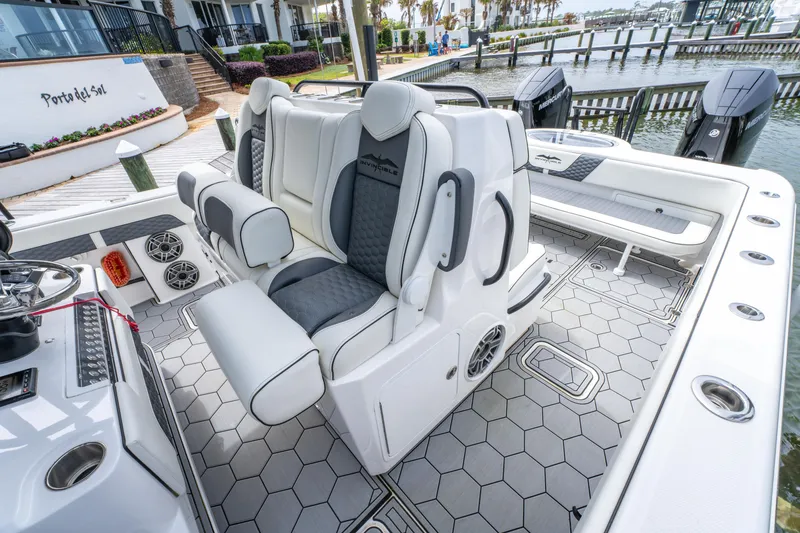 Slide: The Image of 2024 Invincible 33 Catamaran interior with luxurious seating and modern design at a marina. - 7