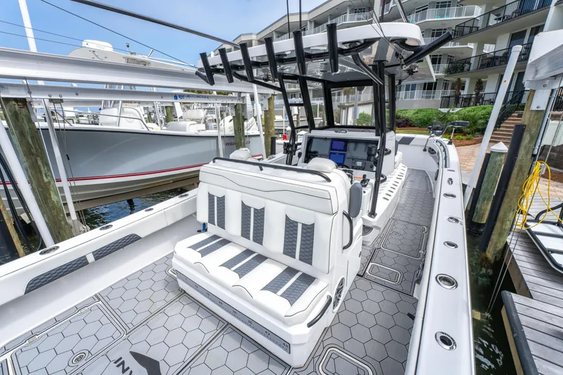 Slide: The Image of 2024 Invincible 33 Catamaran with sleek seating and modern design at a marina dock. - 8