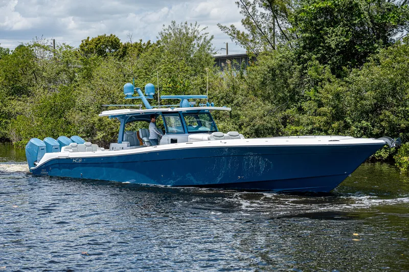 Slide: The Image of 2023 HCB 53 Sueños boat cruising on a river, surrounded by lush greenery. - 0