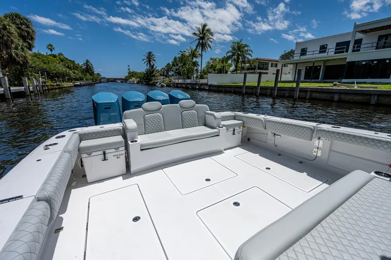 Slide: The Image of 2023 HCB 53 Sueños boat with spacious seating, docked by a waterfront home. - 10