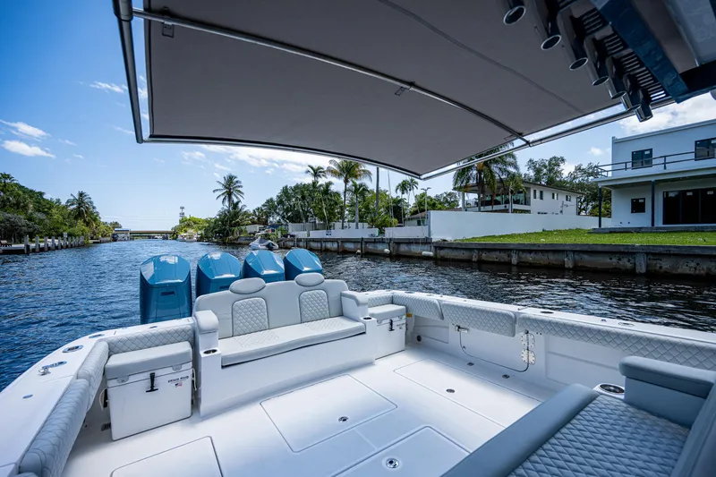 Slide: The Image of HCB 53 Sueños 2023 boat with spacious deck and luxurious seating on a sunny waterway. - 11