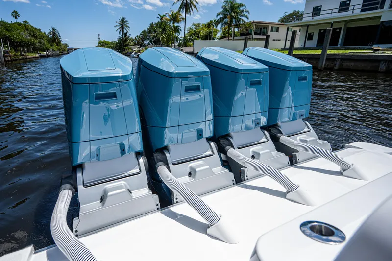 Slide: The Image of Four blue outboard motors on a 2023 HCB 53 Sueños boat, docked by a canal. - 12