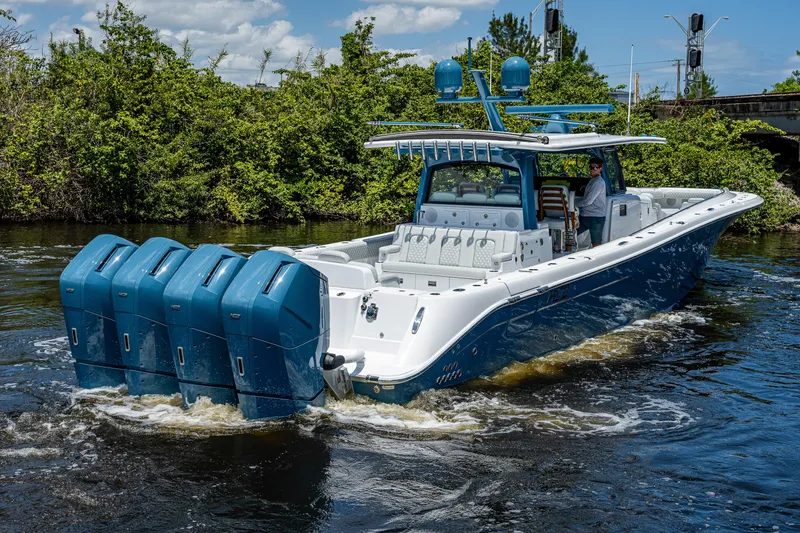 Slide: The Image of 2023 HCB 53 Sueños boat with multiple outboard engines cruising on a river. - 2