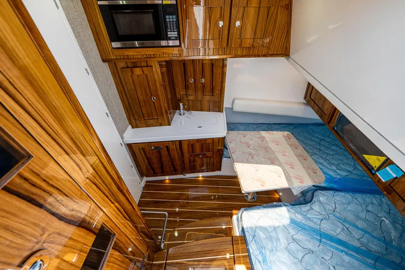 Slide: The Image of 2023 HCB 53 Sueños interior with wood cabinetry, kitchenette, and cozy sleeping area. - 42
