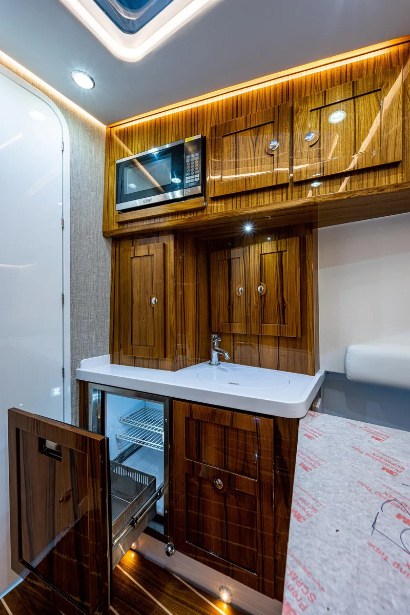 Slide: The Image of 2023 HCB 53 Sueños yacht interior with wooden cabinetry, sink, and microwave. - 44