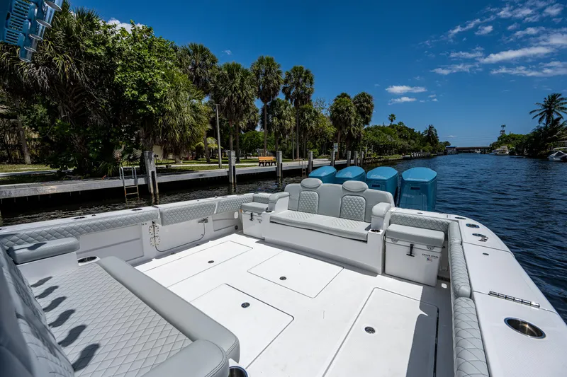 Slide: The Image of 2023 HCB 53 Sueños boat with spacious deck, docked by a scenic waterway. - 8