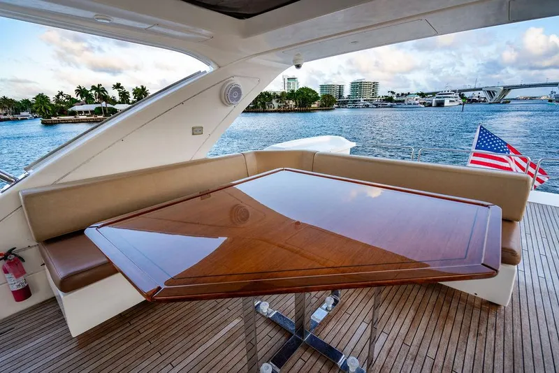 Slide: The Image of Luxurious 2011 Azimut 70 Fly yacht deck with elegant wooden table and scenic waterfront view. - 10
