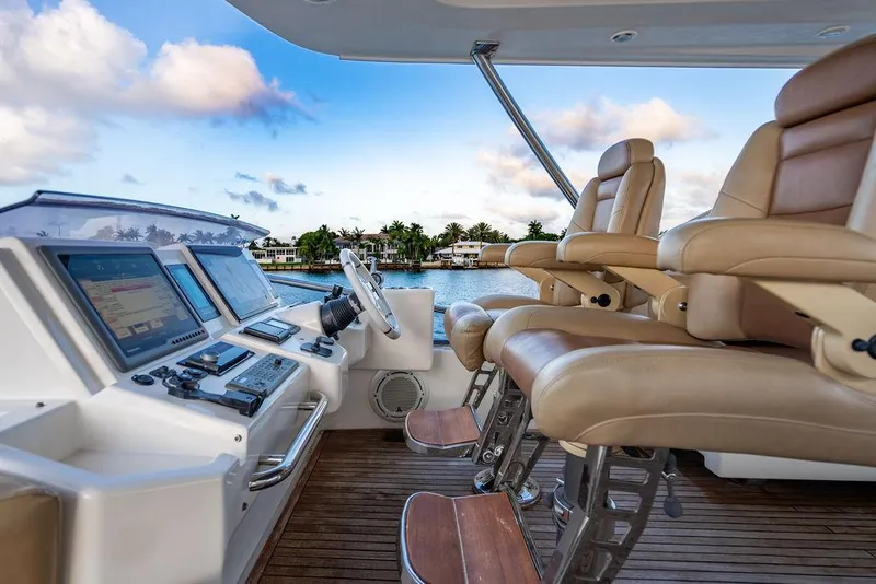 Slide: The Image of Luxury helm of 2011 Azimut 70 Fly yacht with leather seats and navigation controls. - 15