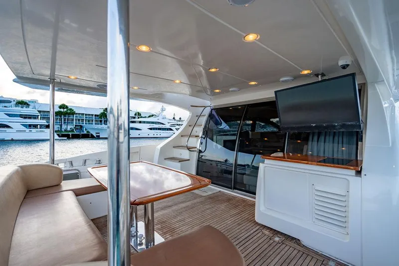 Slide: The Image of Luxurious 2011 Azimut 70 Fly yacht deck with seating, table, and TV, docked at marina. - 8