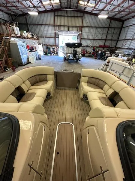 Slide: The Image of 2023 Starcraft SX 23 Q DC boat with spacious seating in a warehouse setting. - 13