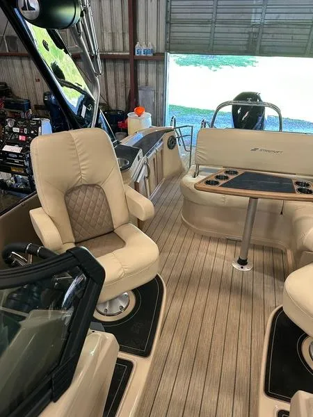 Slide: The Image of 2023 Starcraft SX 23 Q DC boat interior with beige seating and wood flooring. - 15