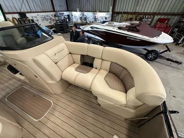 Slide: The Image of 2023 Starcraft SX 23 Q DC boat with luxurious beige seating in a showroom. - 17