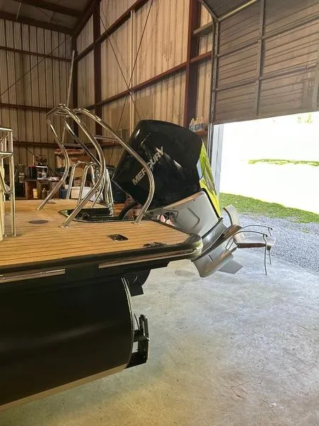 Slide: The Image of 2023 Starcraft SX 23 Q DC boat with Mercury outboard in a storage facility. - 3