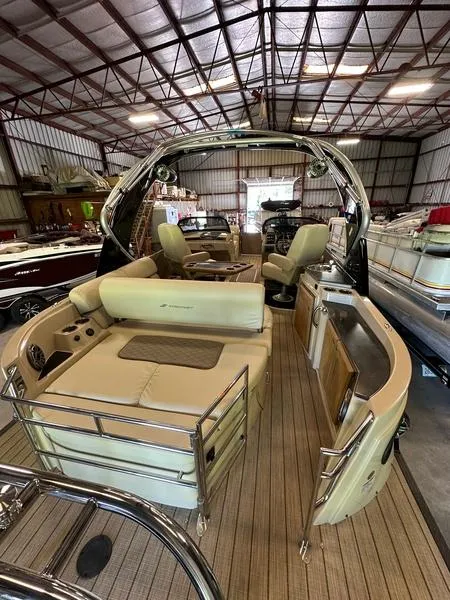 Slide: The Image of 2023 Starcraft SX 23 Q DC boat interior with beige seating in a storage facility. - 5