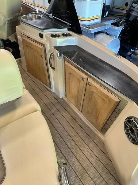 Slide: The Image of 2023 Starcraft SX 23 Q DC boat interior with wooden cabinets and sleek countertops. - 7
