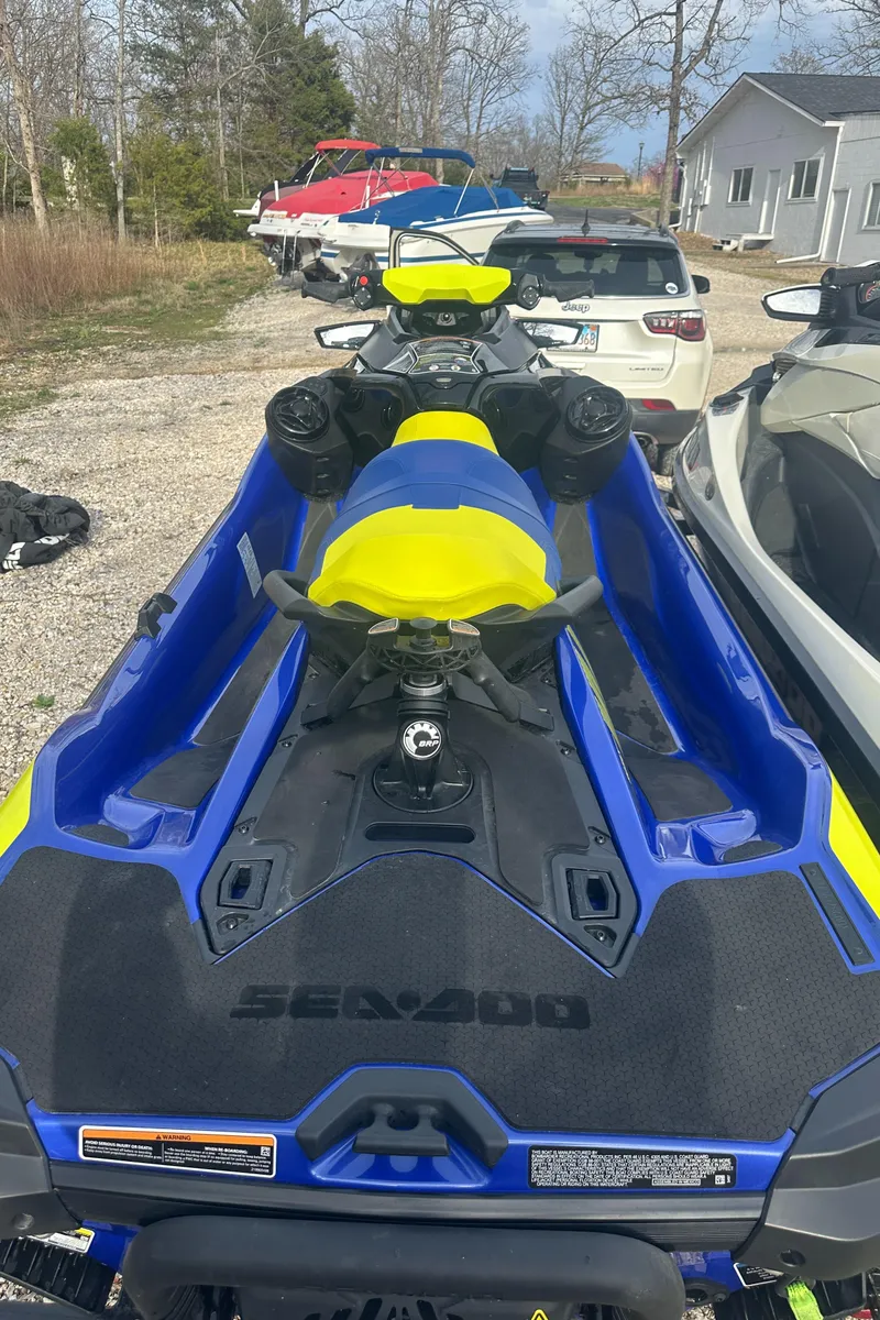 Slide: The Image of 2021 Sea-Doo Wake Pro 230 jet ski in vibrant blue and yellow, parked outdoors. - 16