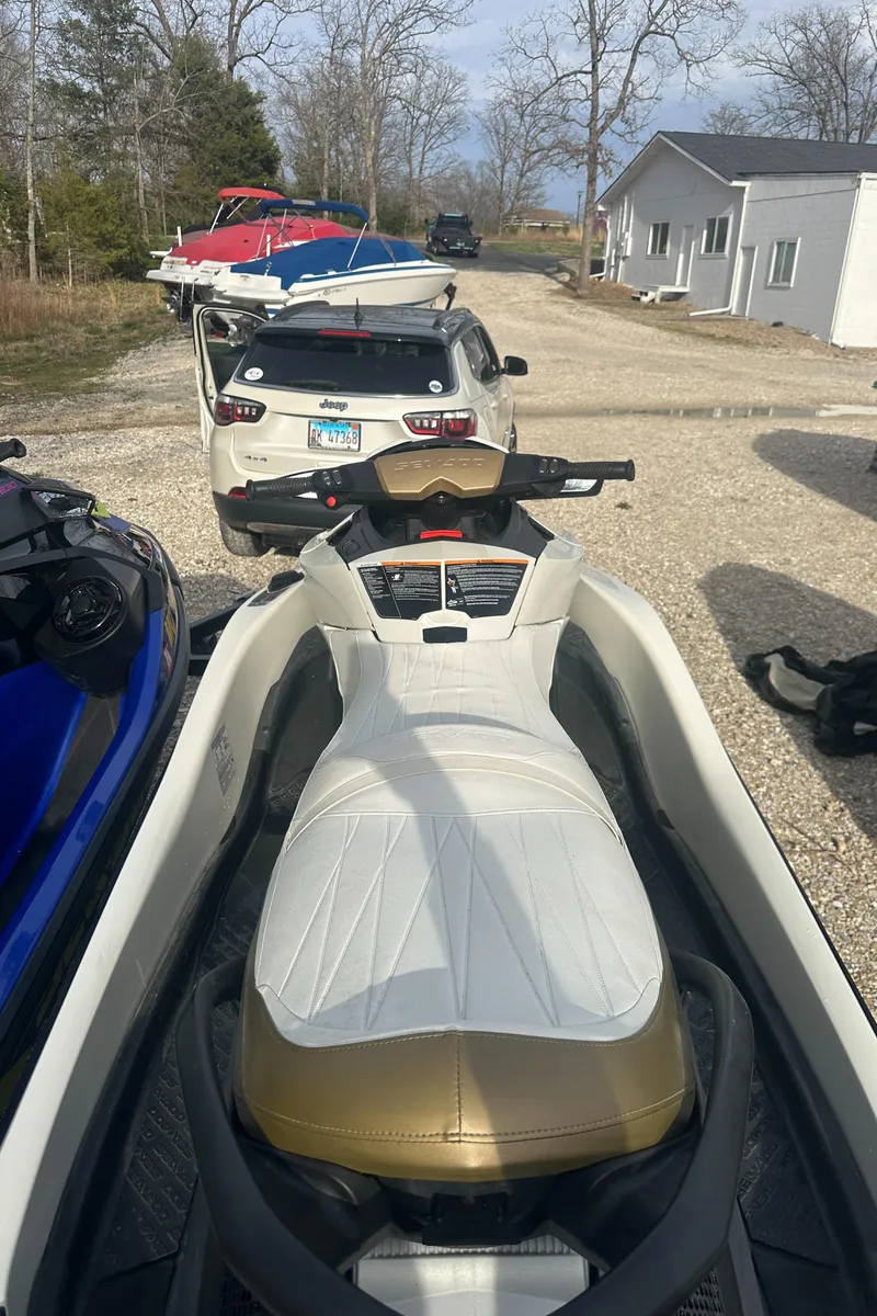Slide: The Image of 2021 Sea-Doo Wake Pro 230 jet ski parked on gravel driveway near vehicles and trees. - 24