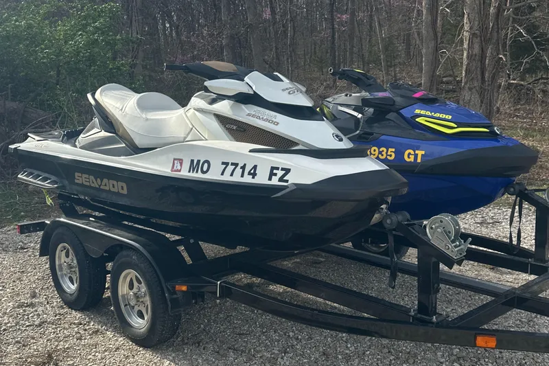 Slide: The Image of 2021 Sea-Doo Wake Pro 230 jet skis on a trailer in a wooded area. - 3