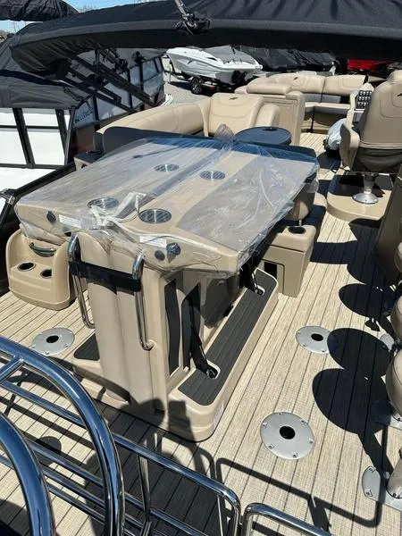 Slide: The Image of 2023 Starcraft CX25DL Bar boat interior with seating and table setup. - 11