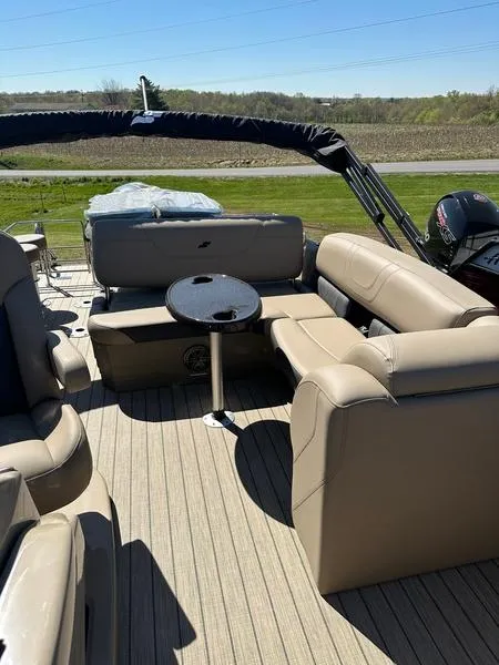 Slide: The Image of 2023 Starcraft CX25DL Bar pontoon boat with beige seating and a small round table. - 15