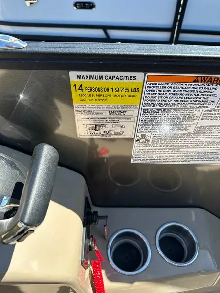 Slide: The Image of 2023 Starcraft CX25DL Bar boat capacity label, 14 persons or 1975 lbs, with warning details. - 6