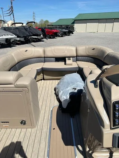 Slide: The Image of 2023 Starcraft CX25DL Bar pontoon boat interior with beige seating and wood-style flooring. - 8