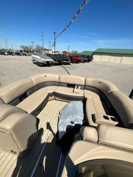 Slide: The Image of 2023 Starcraft CX25DL Bar pontoon boat with beige seating, displayed outdoors. - 9