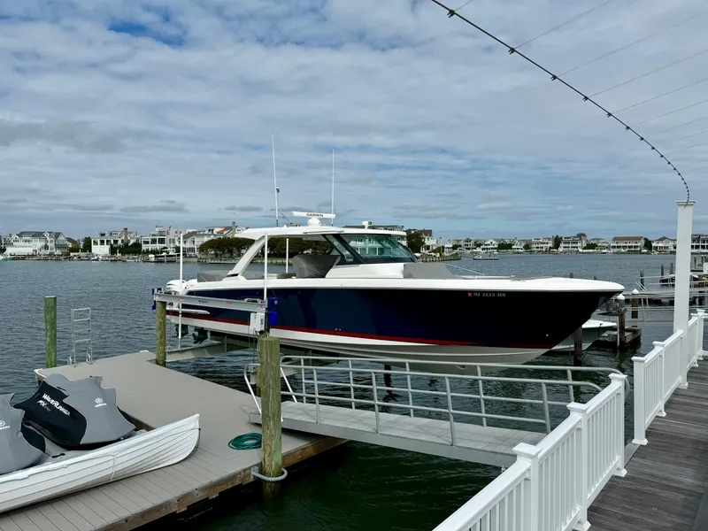 Slide: The Image of 2022 Tiara Yachts 43 LS docked at a marina under a cloudy sky. - 10