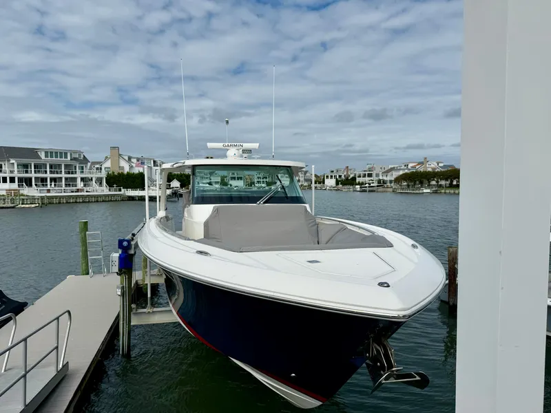 Slide: The Image of 2022 Tiara Yachts 43 LS docked in a marina with waterfront homes in the background. - 12