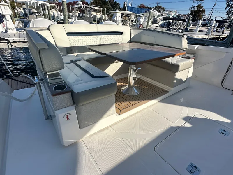 Slide: The Image of 2022 Tiara Yachts 43 LS luxury seating area with table, docked at marina. - 13