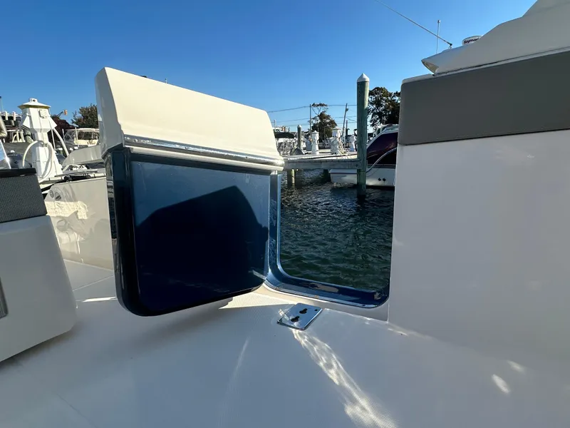 Slide: The Image of 2022 Tiara Yachts 43 LS boat with open side door, docked at marina. - 18