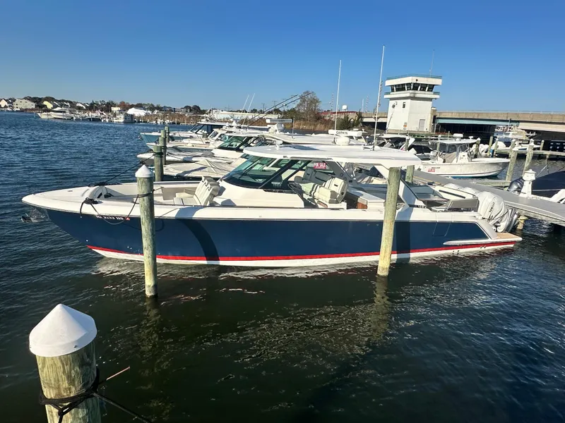 Slide: The Image of 2022 Tiara Yachts 43 LS docked in a marina under clear blue skies. - 2
