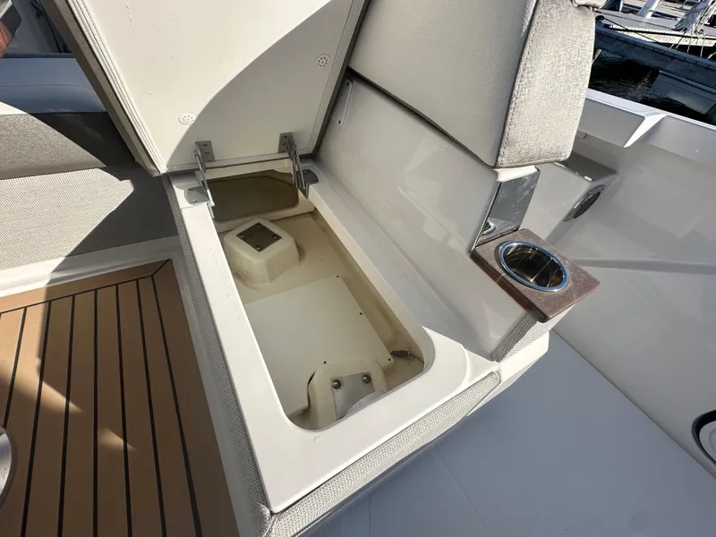 Slide: The Image of Storage compartment on 2022 Tiara Yachts 43 LS with cup holder and cushioned seating. - 22