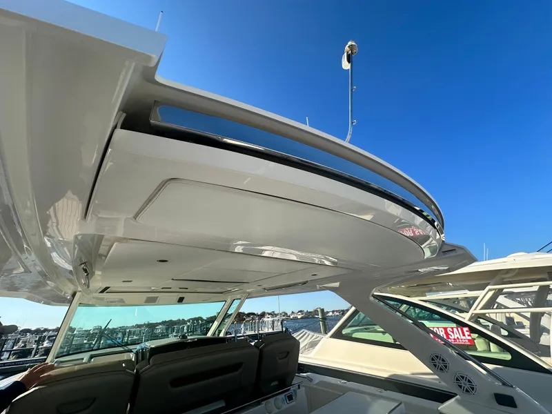 Slide: The Image of 2022 Tiara Yachts 43 LS with sleek design, showcased under clear blue sky. - 25