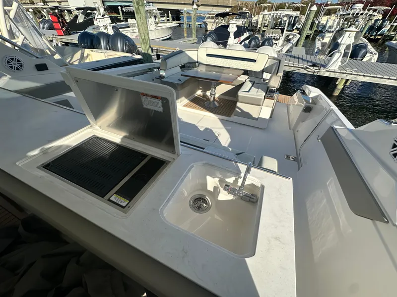 Slide: The Image of 2022 Tiara Yachts 43 LS with outdoor sink and grill, docked at marina. - 26