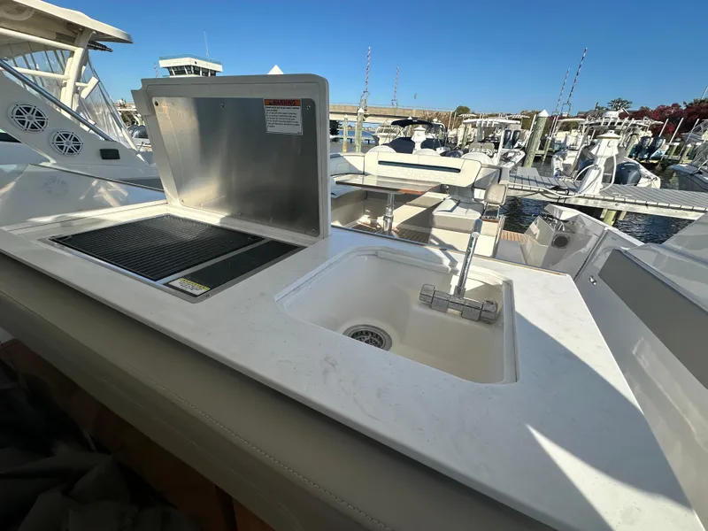 Slide: The Image of Outdoor kitchen area on 2022 Tiara Yachts 43 LS, featuring a sink and grill. - 27