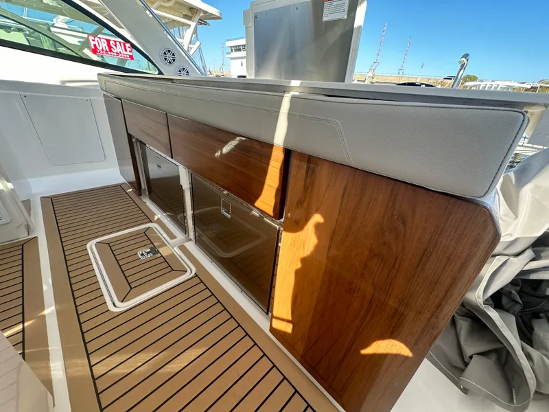 Slide: The Image of 2022 Tiara Yachts 43 LS interior with wood cabinetry and cushioned seating, "For Sale" sign visible. - 28