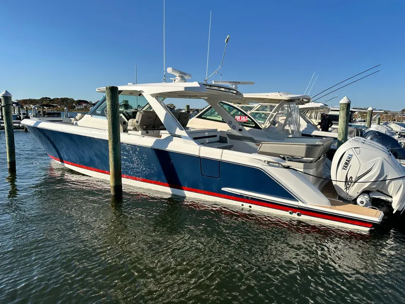 Slide: The Image of 2022 Tiara Yachts 43 LS boat docked in marina, featuring sleek design and Yamaha engines. - 3