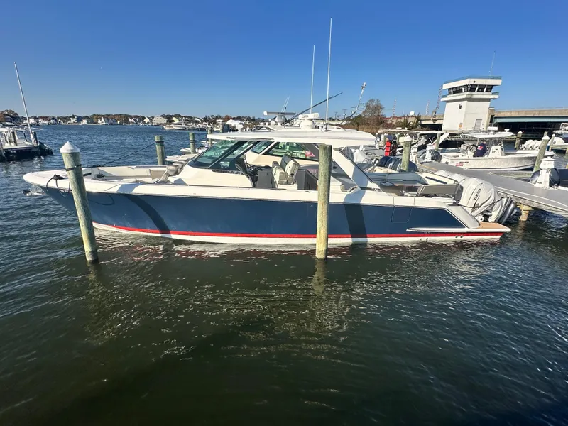 Slide: The Image of 2022 Tiara Yachts 43 LS docked in a marina under clear blue skies. - 4