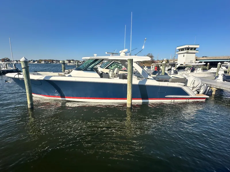 Slide: The Image of 2022 Tiara Yachts 43 LS docked in a marina under clear blue skies. - 5