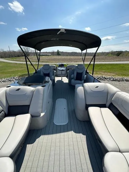Slide: The Image of 2023 Starcraft SLS-3 pontoon boat with spacious seating and canopy on a sunny day. - 14