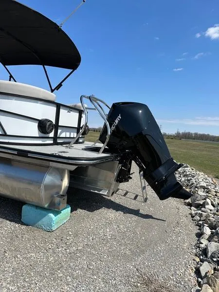 Slide: The Image of 2023 Starcraft SLS-3 pontoon boat with Mercury outboard motor on gravel surface. - 3